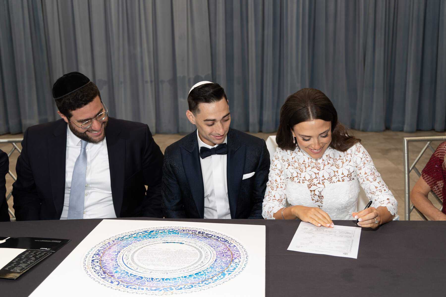 Ketubah signing ceremony with family gathered around custom Jewish marriage contract