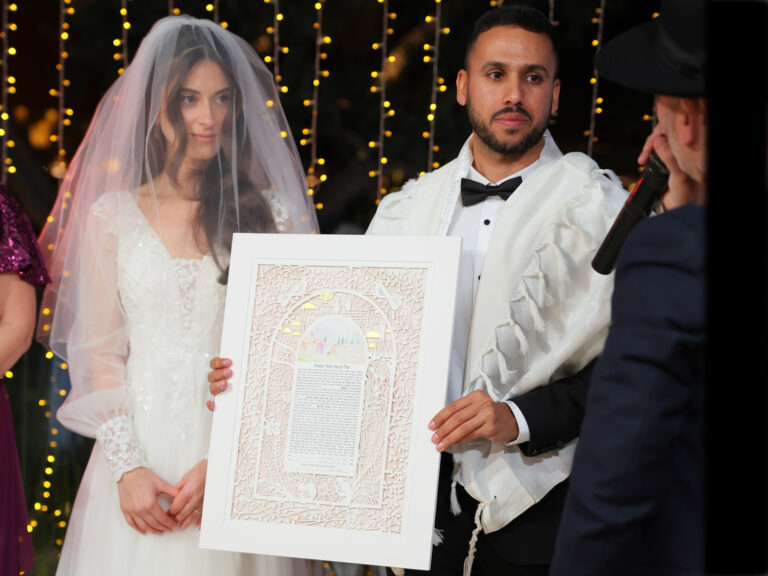 Eretz Ahuva ketubah papercut design with watercolor background during a Jewish wedding ceremony