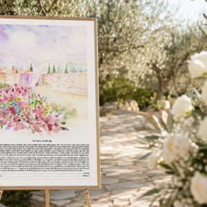 Jerusalem watercolor ketubah displayed at an outdoor Jewish wedding